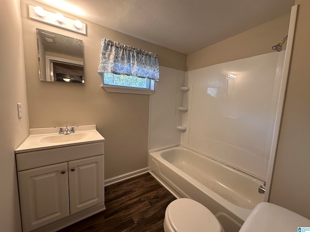 full bathroom with wood-type flooring, washtub / shower combination, vanity, and toilet