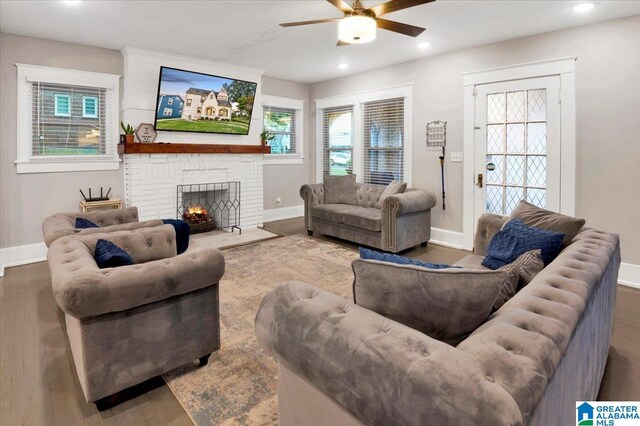 living room with a brick fireplace, ceiling fan, and hardwood / wood-style floors