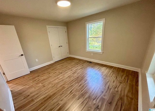 unfurnished bedroom with light hardwood / wood-style flooring and a closet