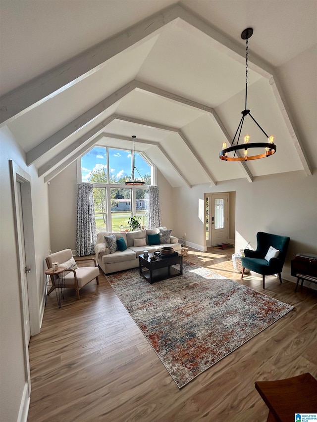 living room with wood-type flooring, a notable chandelier, and lofted ceiling