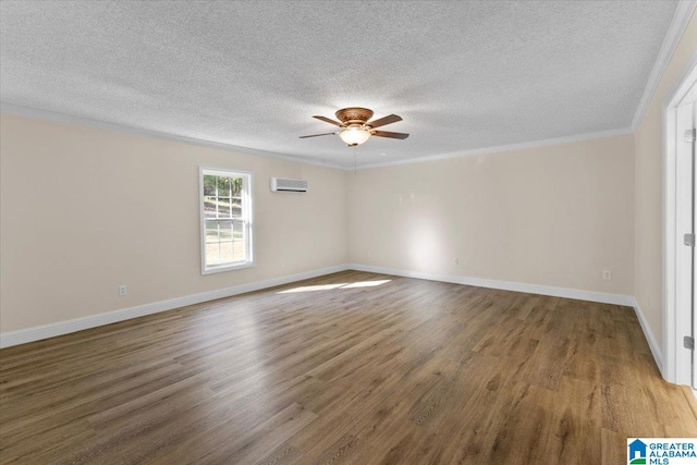 spare room with ceiling fan, hardwood / wood-style flooring, crown molding, a wall mounted AC, and a textured ceiling