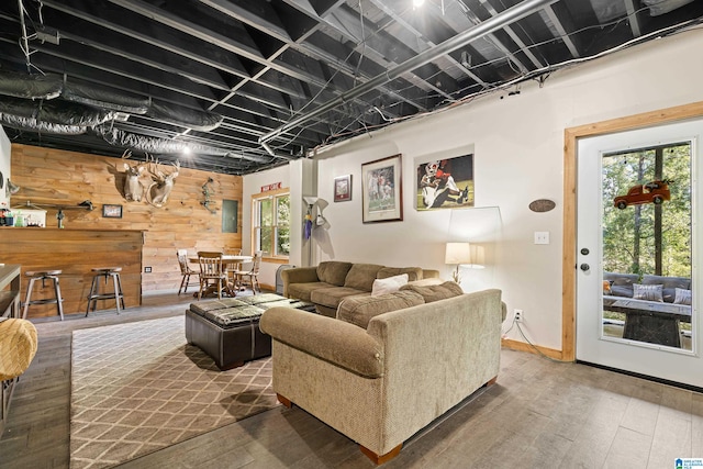 living room featuring plenty of natural light, wood walls, and wood-type flooring