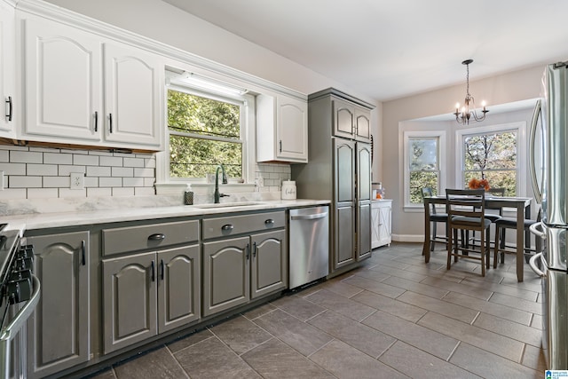 kitchen featuring gray cabinetry, sink, stainless steel appliances, backsplash, and white cabinetry