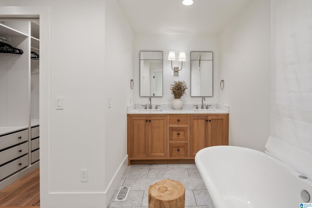 bathroom with hardwood / wood-style floors, vanity, and a washtub