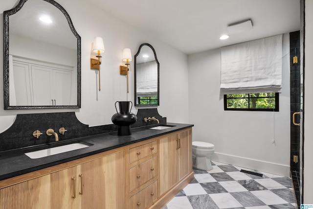 bathroom with a shower with shower door, vanity, and toilet