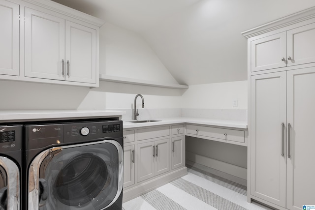 laundry area with washing machine and clothes dryer, cabinets, light tile patterned floors, and sink