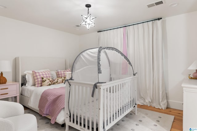 bedroom featuring a notable chandelier and light hardwood / wood-style floors