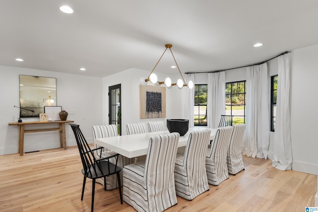 dining space featuring light hardwood / wood-style flooring and a chandelier