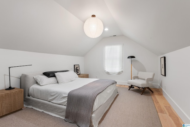 bedroom with lofted ceiling and light hardwood / wood-style floors