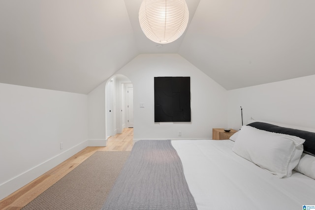 bedroom featuring light wood-type flooring and lofted ceiling