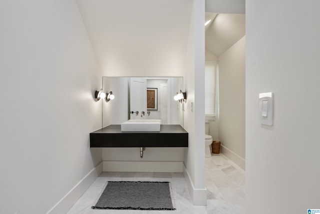 bathroom with vanity, toilet, and vaulted ceiling