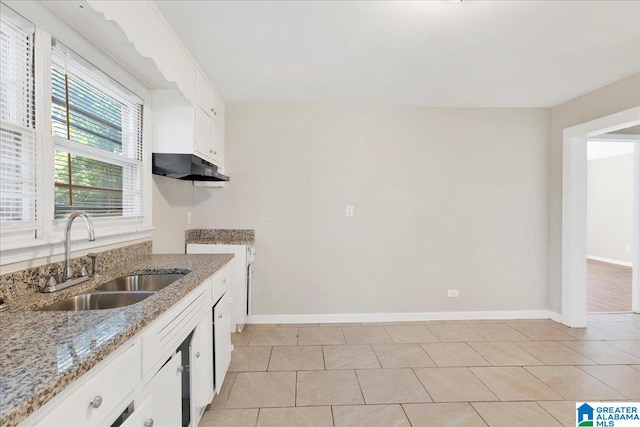 kitchen featuring light tile patterned floors, light stone countertops, sink, and white cabinetry