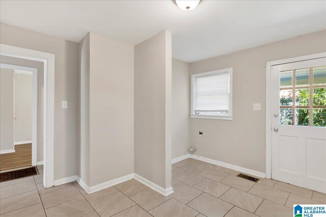 laundry room with hookup for an electric dryer and light tile patterned floors