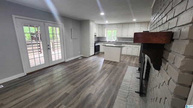 kitchen featuring dark wood-type flooring, white cabinets, a kitchen island, french doors, and stainless steel range with electric cooktop