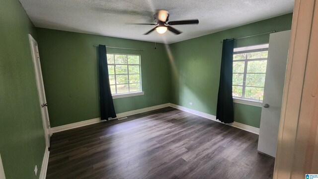 empty room featuring a textured ceiling, dark hardwood / wood-style flooring, and ceiling fan