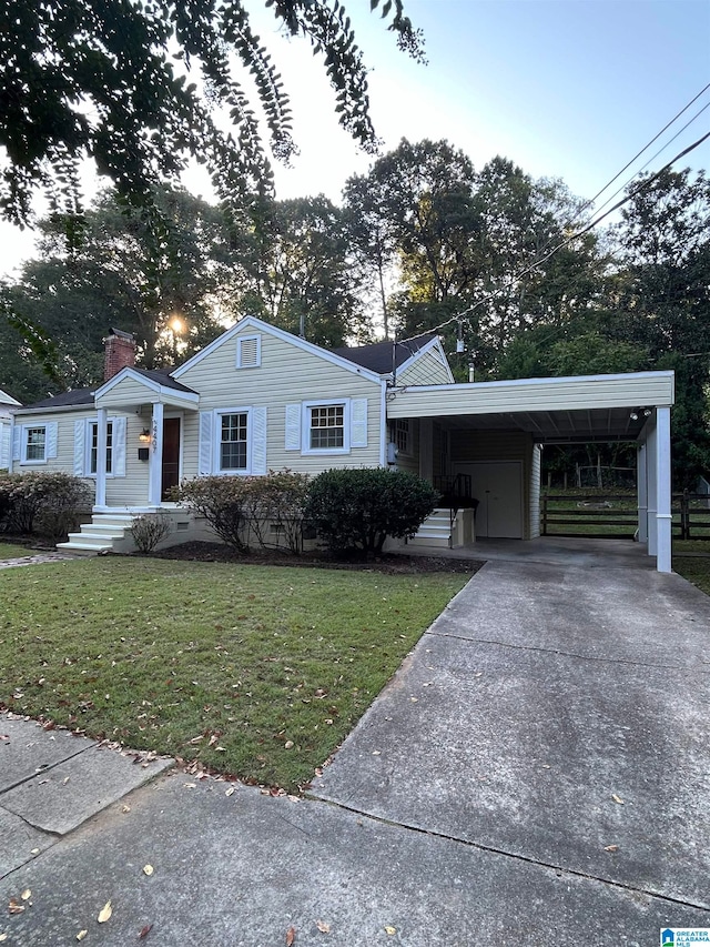 view of front of property featuring a front yard and a carport