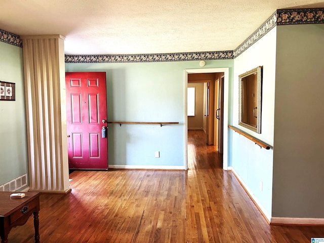 interior space with a textured ceiling and hardwood / wood-style floors