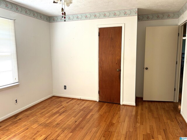 unfurnished bedroom with light hardwood / wood-style floors and a textured ceiling