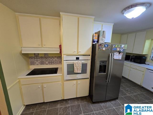 kitchen featuring dark tile patterned flooring and white appliances