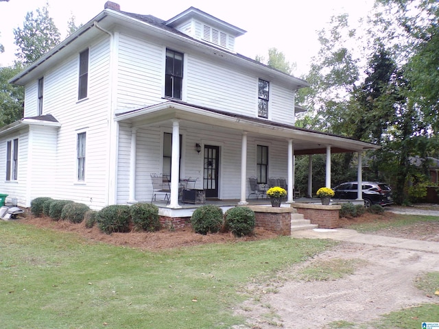 farmhouse with a front lawn and covered porch