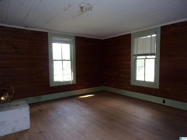 empty room with wood walls and hardwood / wood-style flooring