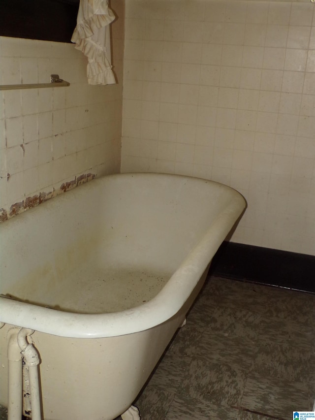 bathroom with tile walls and a tub