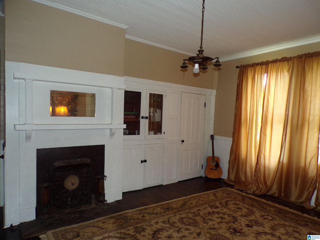 unfurnished living room with a notable chandelier, a fireplace, crown molding, and dark hardwood / wood-style flooring