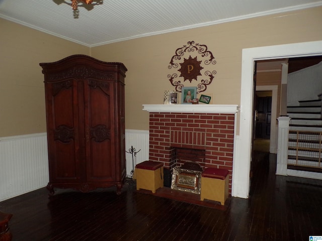 living room with radiator heating unit, ornamental molding, dark wood-type flooring, and a brick fireplace