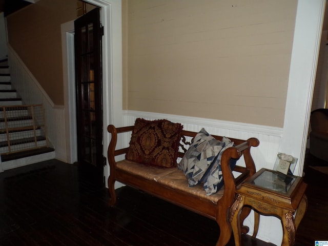 living area with hardwood / wood-style floors, a wainscoted wall, stairway, and a decorative wall