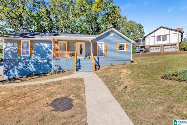 view of front of property featuring covered porch, a front yard, and a garage