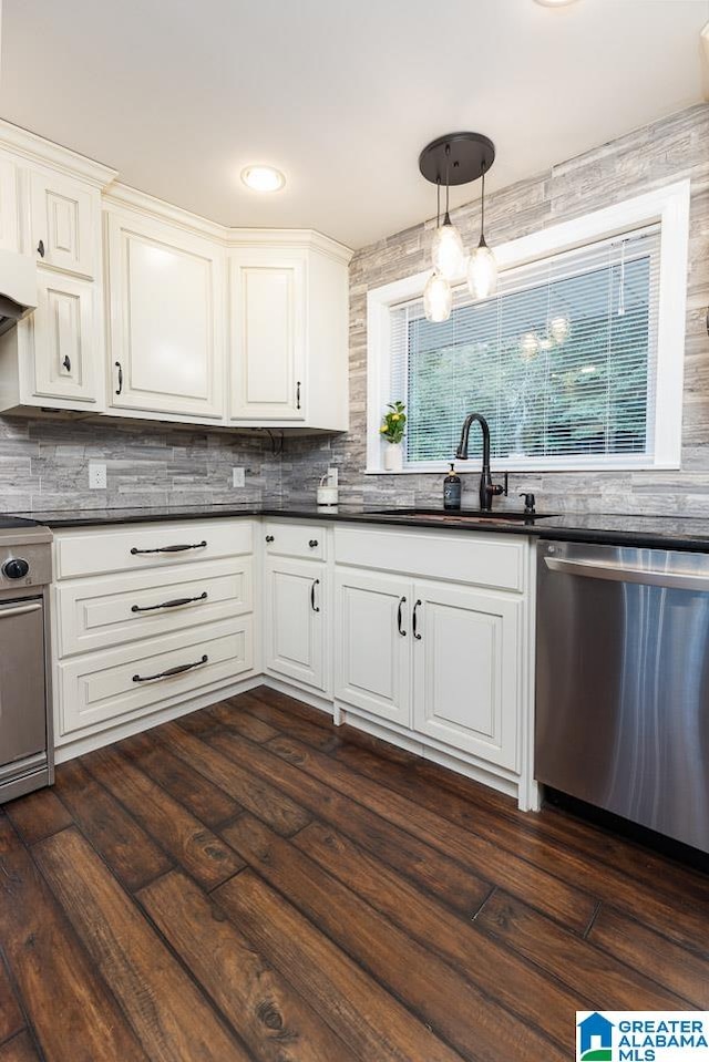 kitchen with sink, decorative light fixtures, white cabinetry, appliances with stainless steel finishes, and dark hardwood / wood-style floors