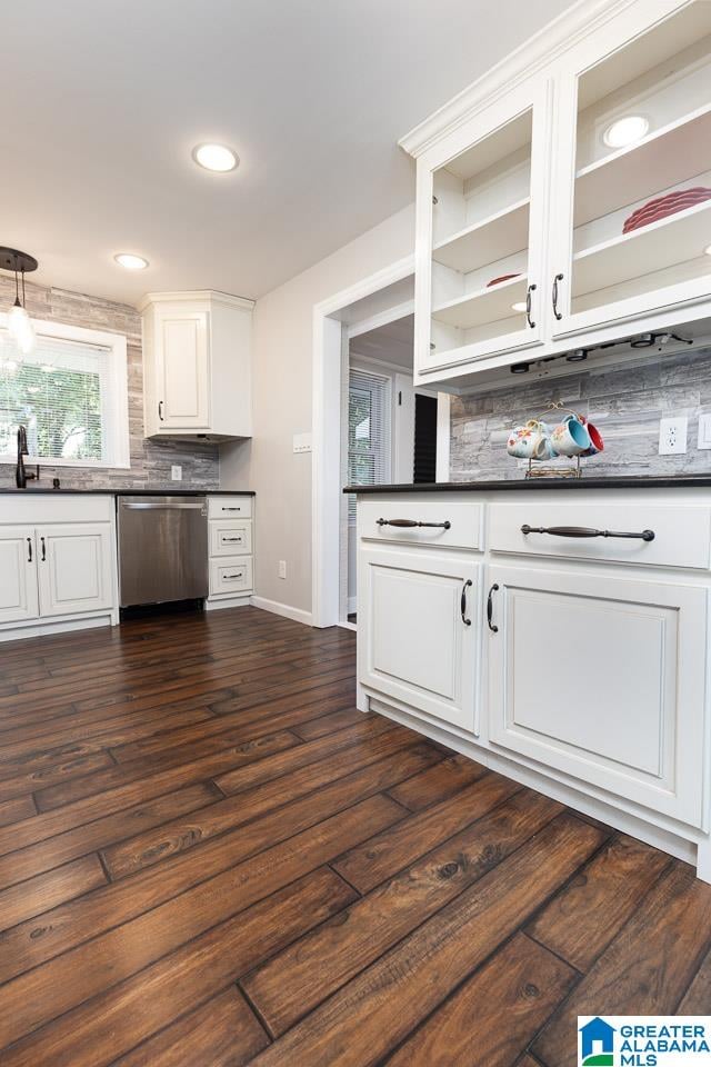 kitchen with dark wood-type flooring, sink, white cabinets, decorative backsplash, and stainless steel dishwasher