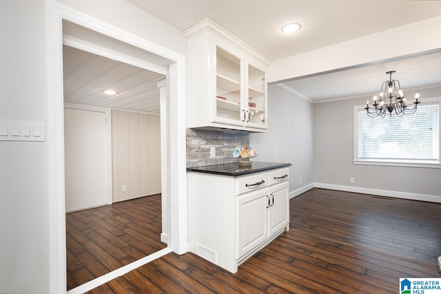 kitchen with hanging light fixtures, white cabinets, backsplash, crown molding, and dark hardwood / wood-style floors