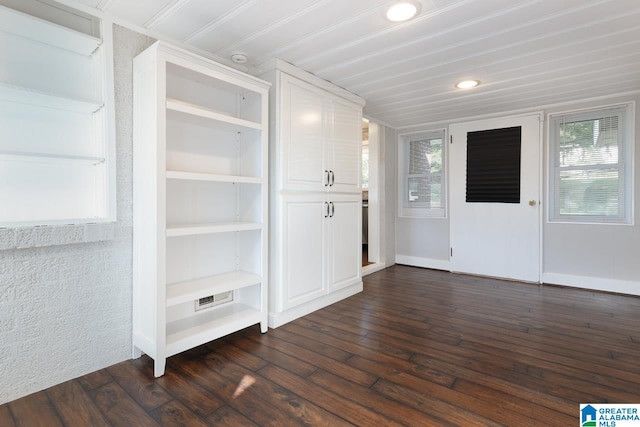 interior space with a healthy amount of sunlight, built in shelves, and dark wood-type flooring