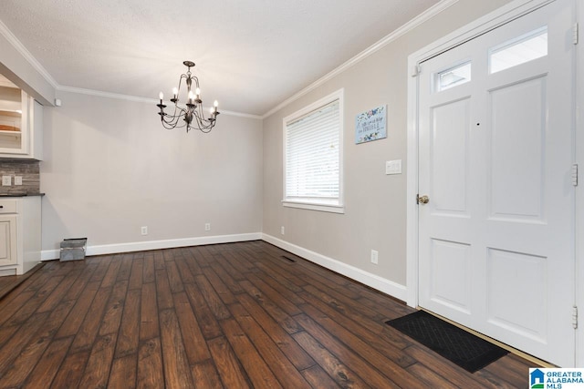 unfurnished dining area with a notable chandelier, a textured ceiling, dark hardwood / wood-style floors, and ornamental molding