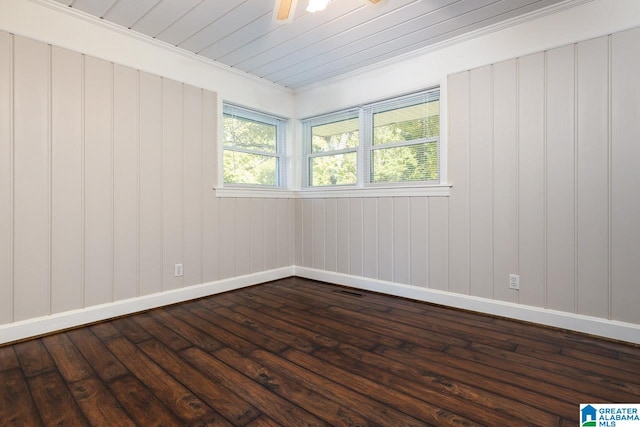 spare room featuring dark wood-type flooring and crown molding