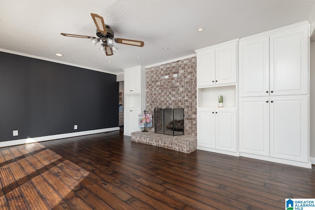 unfurnished living room with ceiling fan, ornamental molding, a textured ceiling, dark hardwood / wood-style floors, and a fireplace