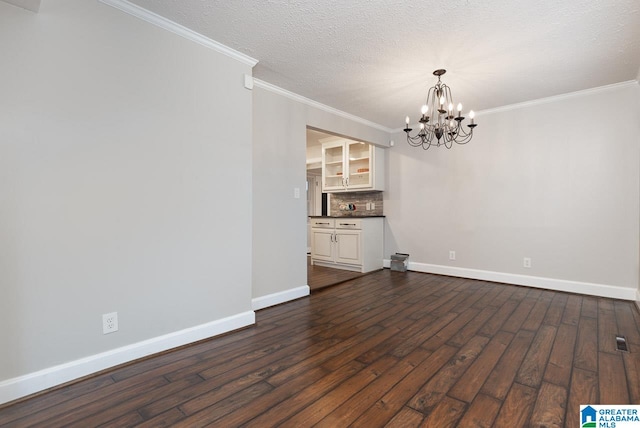 interior space featuring an inviting chandelier, a textured ceiling, dark hardwood / wood-style floors, and ornamental molding