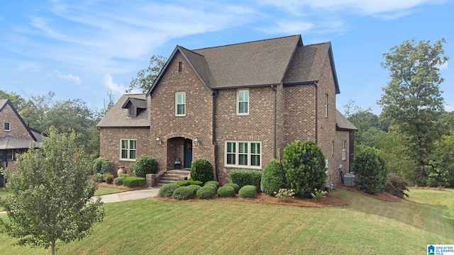 view of front facade featuring a front lawn and central air condition unit