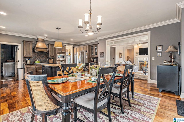 dining area featuring a notable chandelier, crown molding, and light hardwood / wood-style floors