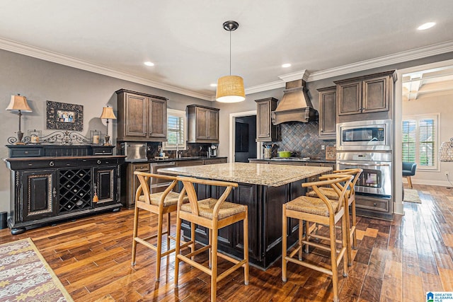 kitchen featuring premium range hood, dark hardwood / wood-style floors, crown molding, and a healthy amount of sunlight