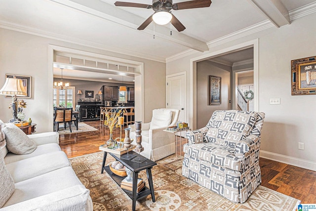 living room featuring ceiling fan with notable chandelier, wood-type flooring, and crown molding