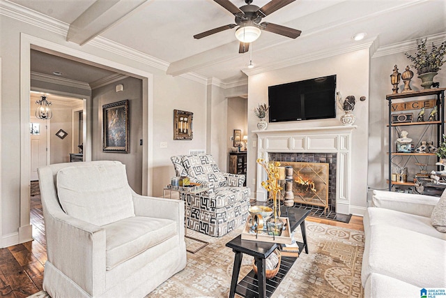 living room featuring ornamental molding, beam ceiling, a tiled fireplace, and hardwood / wood-style flooring