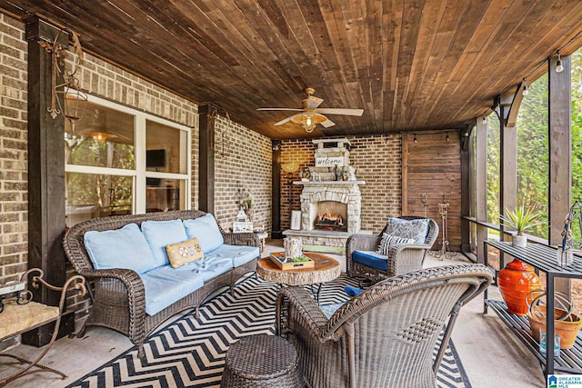 sunroom / solarium featuring ceiling fan, wood ceiling, and an outdoor stone fireplace