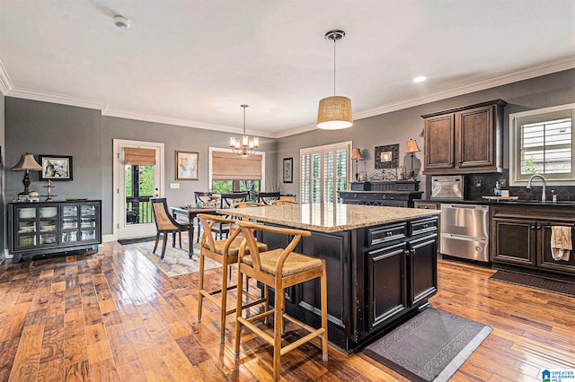 kitchen featuring light hardwood / wood-style floors, plenty of natural light, a kitchen island, and decorative light fixtures