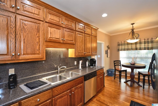 kitchen featuring decorative backsplash, light hardwood / wood-style flooring, stainless steel appliances, crown molding, and sink