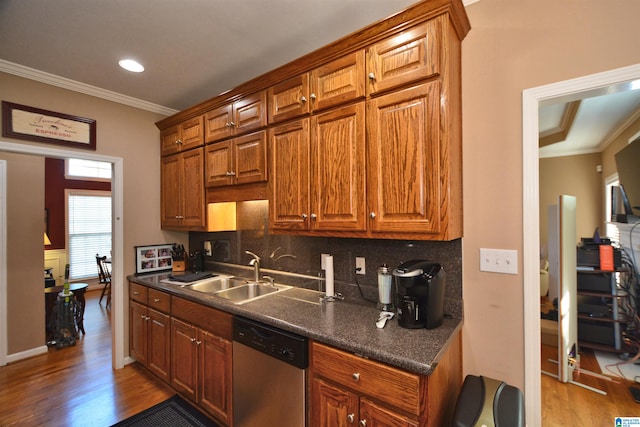 kitchen with sink, dishwasher, ornamental molding, and light hardwood / wood-style floors