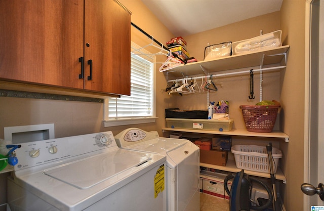 clothes washing area with washer and clothes dryer, tile patterned flooring, and cabinets