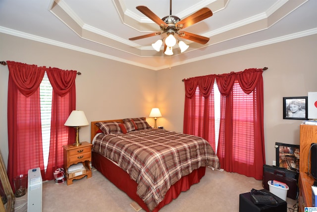 carpeted bedroom featuring ceiling fan, ornamental molding, and a tray ceiling