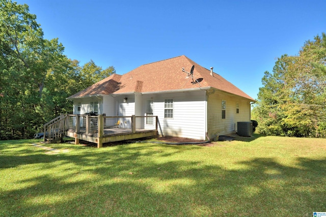 rear view of house featuring a deck, central AC unit, and a lawn